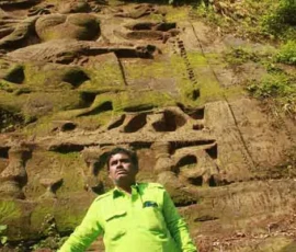 Ramapada Acharjee exploring ancient rock-cut sculptures and Vedic heritage at a historic site during his spiritual journey