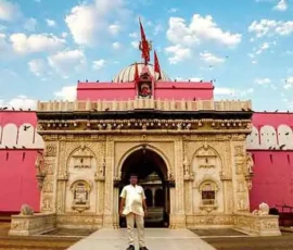 Ramapada Acharjee at the grand entrance of a historic Vedic heritage site during a spiritual tour